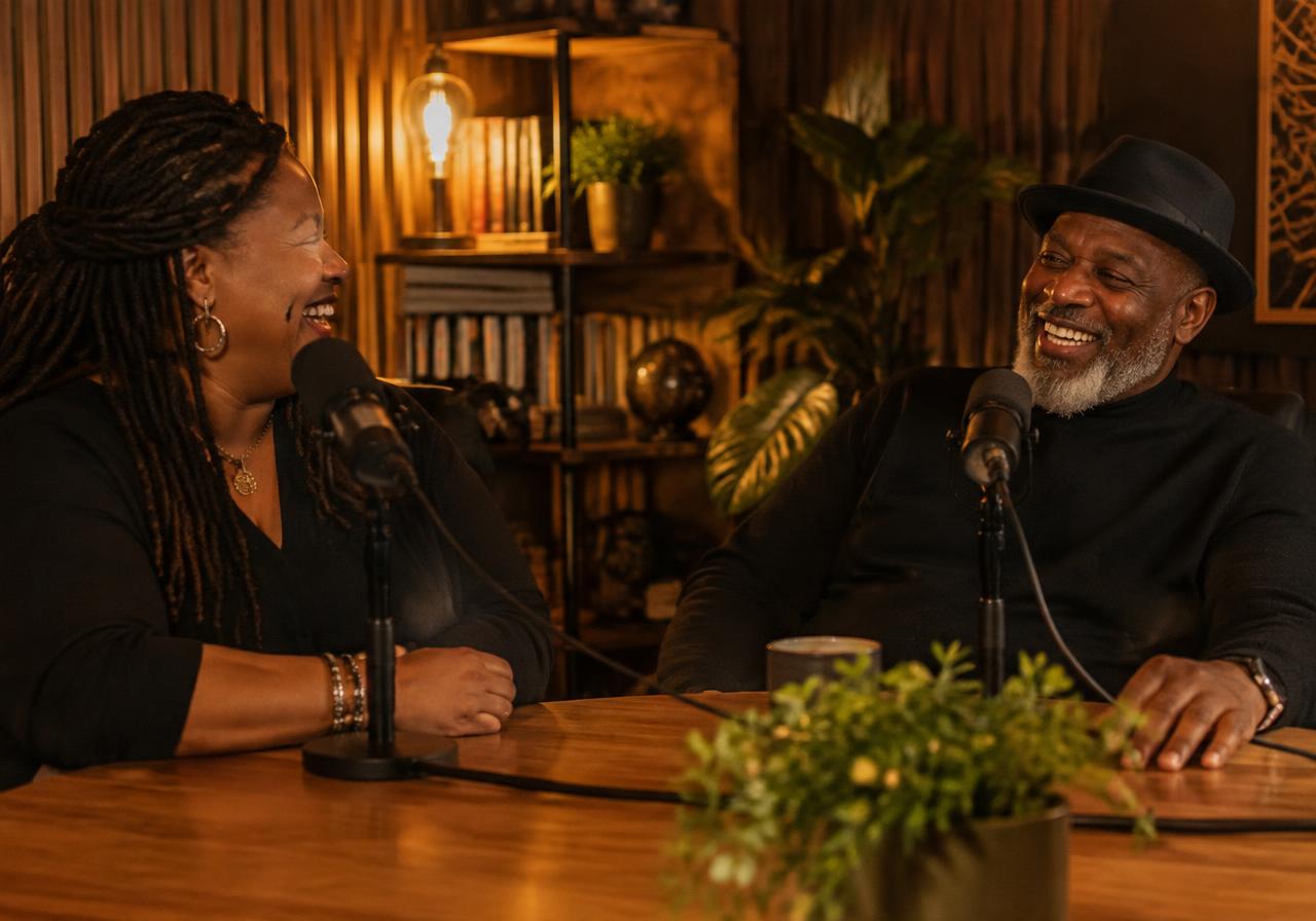 Two people laughing during a podcast recording